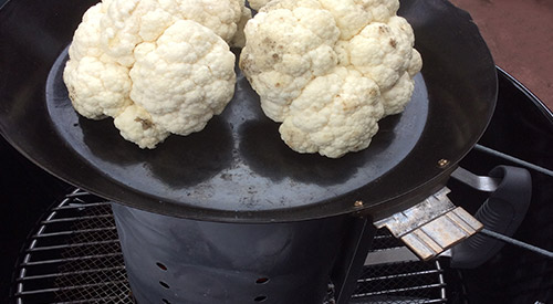 We are cooking on a chimney starter with a grill pan to nicely char our head of Cauliflower for this recipe!