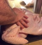 Using your hands to push down and flatten the Turkey on the cooking sheet allows for an even cook! 